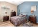 Cozy bedroom with a blue accent wall, two nightstands, and a window letting in natural light at 2212 W Calle De Las Estrella St, Phoenix, AZ 85085
