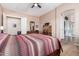 Bedroom features a decorative quilt on the bed, a dressing table and wood-look floors, and an ensuite bath at 2212 W Calle De Las Estrella St, Phoenix, AZ 85085