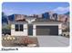 Charming single-story home featuring stone accents, a two-car garage, and desert landscaping with mountain views at 23984 W Cocopah St, Buckeye, AZ 85326