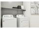 Efficient laundry room with modern washer and dryer, plus shelving for organized storage at 23984 W Cocopah St, Buckeye, AZ 85326
