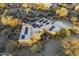 Aerial view showcasing the home's desert landscaping, solar panels, pool, and expansive surroundings at 25031 N Paso Trl, Scottsdale, AZ 85255