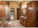 Bathroom featuring wooden cabinets, a walk-in shower, and access to the backyard at 25031 N Paso Trl, Scottsdale, AZ 85255