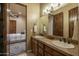 Bathroom with double sinks, stone countertops, and wooden cabinets at 25031 N Paso Trl, Scottsdale, AZ 85255