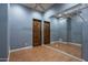 Bonus room featuring laminate wood floor, with dual wood doors, and large mirror at 25031 N Paso Trl, Scottsdale, AZ 85255