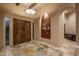 Elegant foyer featuring double doors, decorative rug, art niche, and arched doorways at 25031 N Paso Trl, Scottsdale, AZ 85255