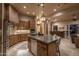 Spacious kitchen featuring custom cabinetry, stainless steel appliances, and island with pendant lighting at 25031 N Paso Trl, Scottsdale, AZ 85255