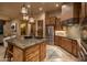 Open kitchen with a large island, stainless appliances, custom cabinetry, and stylish pendant lights at 25031 N Paso Trl, Scottsdale, AZ 85255