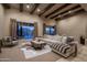 Open living room with beamed ceilings, plush sofa, decorative rug, and scenic backyard views at 25031 N Paso Trl, Scottsdale, AZ 85255