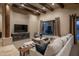 Spacious living area featuring beamed ceilings, comfortable seating, and a large window showcasing the backyard at 25031 N Paso Trl, Scottsdale, AZ 85255