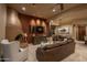 Comfortable living room featuring tile flooring, a rustic fireplace, and a seamless flow into the dining area at 25031 N Paso Trl, Scottsdale, AZ 85255