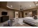 Relaxing main bedroom features a sitting area, a ceiling fan, and ample natural light at 25031 N Paso Trl, Scottsdale, AZ 85255