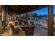 Relaxing covered patio with ceiling fan, dining set, fire pit and view of the custom pool area at 25031 N Paso Trl, Scottsdale, AZ 85255