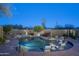 Beautiful in-ground pool featuring in-pool seating, desert landscaping, and a small waterfall feature at 25031 N Paso Trl, Scottsdale, AZ 85255