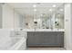 Bright bathroom with a large mirror, soaking tub, and stylish gray double vanity with ample lighting at 28990 N White Feather E Ln # 182, Scottsdale, AZ 85262