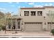 Inviting townhome featuring stone accents, a two-car garage, and a charming front yard at 28990 N White Feather E Ln # 182, Scottsdale, AZ 85262