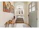 Bright foyer with tiled flooring, a wooden console table, and an open staircase leading to the living area at 28990 N White Feather E Ln # 182, Scottsdale, AZ 85262