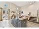 Modern kitchen island with granite countertop and bar seating adjacent to living area and stairway at 28990 N White Feather E Ln # 182, Scottsdale, AZ 85262
