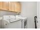 Functional laundry room with front load washer and dryer and storage cabinets above at 28990 N White Feather E Ln # 182, Scottsdale, AZ 85262