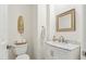 Neat powder room includes a white vanity, marble countertop, and decorative mirror at 28990 N White Feather E Ln # 182, Scottsdale, AZ 85262