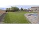 Expansive backyard featuring a large grassy area with retaining wall, perfect for outdoor activities at 30419 N Plantation Dr, San Tan Valley, AZ 85143