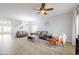 Open living room with tile floors, ceiling fan, large windows, and comfortable seating at 30419 N Plantation Dr, San Tan Valley, AZ 85143