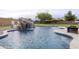 Backyard pool featuring a rock waterfall, spacious patio and view of the green grass at 30419 N Plantation Dr, San Tan Valley, AZ 85143