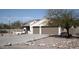 Single-story house with a two-car garage, desert landscaping, and a view of distant mountains at 3721 N Brindley Ave, Litchfield Park, AZ 85340
