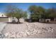 Scenic landscape with desert rock detail, mature trees and a charming bench near garage at 3721 N Brindley Ave, Litchfield Park, AZ 85340