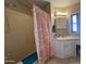 Well-lit bathroom features a tub/shower combination with an orange patterned curtain and a vanity with a decorative mirror at 4065 E University Dr # 471, Mesa, AZ 85205