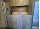 Functional laundry area with a white washer and dryer set, located near a doorway with natural light at 4065 E University Dr # 471, Mesa, AZ 85205
