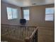 Spacious living room featuring three windows, carpet flooring, and a wrought iron railing at 4134 E Bellerive Dr, Chandler, AZ 85249