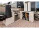 Outdoor kitchen area featuring a grill, smoker, and stone countertop for convenient entertaining at 4381 E Rawhide St, Gilbert, AZ 85296
