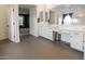 Spacious bathroom featuring a double vanity, white cabinets and dark grey tile flooring at 4381 E Rawhide St, Gilbert, AZ 85296