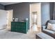 Cozy bedroom with a gray upholstered armchair and a green dresser on a neutral carpet at 4381 E Rawhide St, Gilbert, AZ 85296