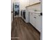 Well-equipped laundry room with a washer, dryer, white cabinets and wood-look tile at 4381 E Rawhide St, Gilbert, AZ 85296