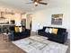 Open-concept living room with modern sofas, light, and an island kitchen at 4381 E Rawhide St, Gilbert, AZ 85296