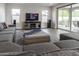 Contemporary living room with large sofa, media center, speakers and sliding door to outdoor seating at 4381 E Rawhide St, Gilbert, AZ 85296