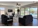 Spacious living room features a ceiling fan, access to the pool, and neutral tones at 4381 E Rawhide St, Gilbert, AZ 85296