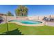 A pristine kidney-shaped pool is surrounded by lush artificial turf, making it the perfect outdoor retreat at 45608 W Barbara Ln, Maricopa, AZ 85139