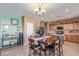 Spacious kitchen and dining area with an island and seating for four, complemented by stylish light fixtures at 45608 W Barbara Ln, Maricopa, AZ 85139