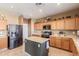 Spacious kitchen with stainless steel appliances, wooden cabinets, and a center island at 45608 W Barbara Ln, Maricopa, AZ 85139