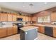 Functional kitchen with a center island, wood cabinets, and ample counter space for meal preparation at 45608 W Barbara Ln, Maricopa, AZ 85139