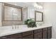 Bathroom with double sinks, white countertops, dark cabinets, decorative mirrors and walk-in shower at 5100 E Rancho Paloma Dr # 2061, Cave Creek, AZ 85331