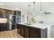 Modern kitchen featuring stainless steel appliances, dark wood cabinets, and a large center island with pendant lighting at 5100 E Rancho Paloma Dr # 2061, Cave Creek, AZ 85331