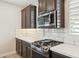 Close-up of a modern kitchen featuring stainless steel appliances, gas range, white countertops, and dark cabinetry at 5100 E Rancho Paloma Dr # 2061, Cave Creek, AZ 85331