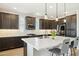 Kitchen featuring dark cabinets, quartz countertops, stainless steel appliances, tile backsplash, and an island with seating at 5100 E Rancho Paloma Dr # 2061, Cave Creek, AZ 85331