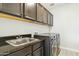 Laundry room featuring modern appliances, dark wood cabinets, and a stainless steel sink at 5100 E Rancho Paloma Dr # 2061, Cave Creek, AZ 85331