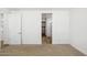 Bright bedroom with an ensuite bathroom and large closet, featuring neutral carpet at 7417 W Buckhorn Trl, Peoria, AZ 85383
