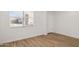 Bedroom showcasing wood-look tile flooring, white walls, and a window with a white-trimmed door at 7417 W Buckhorn Trl, Peoria, AZ 85383