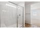 Modern shower with a glass door and marble-style tile, complemented by wood-look flooring at 7417 W Buckhorn Trl, Peoria, AZ 85383